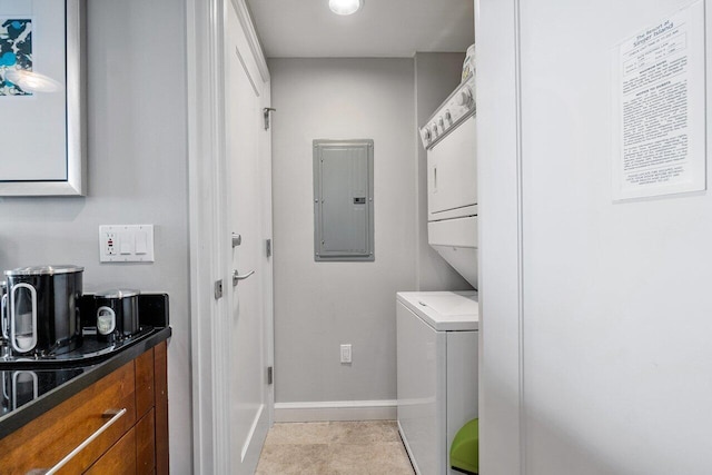 laundry area featuring stacked washer / dryer, electric panel, and light tile patterned floors