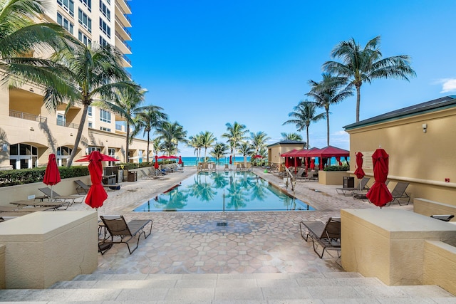 view of pool with a water view and a patio area