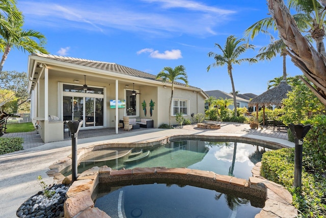 view of swimming pool featuring a patio, ceiling fan, and an outdoor fire pit