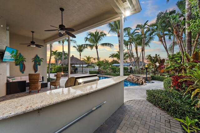 patio terrace at dusk with an outdoor bar and exterior kitchen