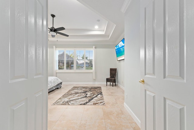 tiled bedroom with ornamental molding, a raised ceiling, and ceiling fan