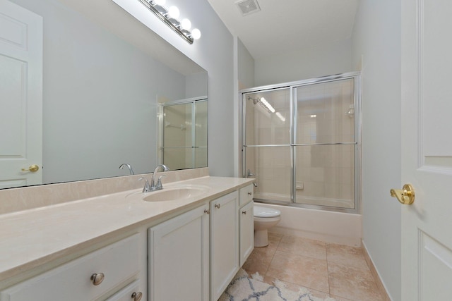 full bathroom with vanity, tile patterned floors, shower / bath combination with glass door, and toilet