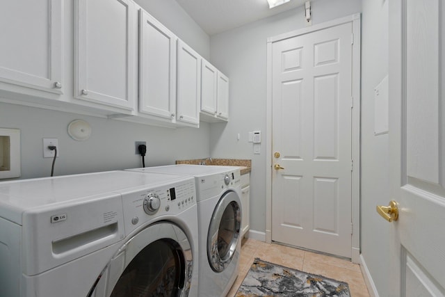 laundry area with separate washer and dryer, cabinets, and light tile patterned flooring