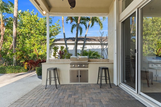 view of patio featuring area for grilling, grilling area, and ceiling fan