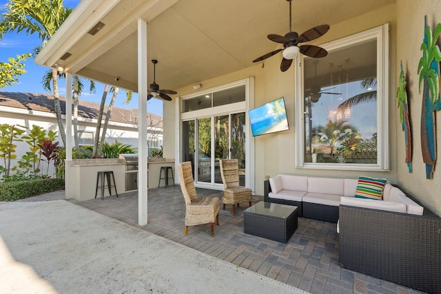 view of patio featuring an outdoor kitchen, a grill, a bar, ceiling fan, and an outdoor living space