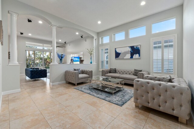 living room featuring ornate columns and light tile patterned floors