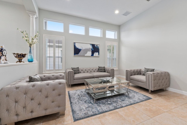 living room with plenty of natural light, light tile patterned floors, and ornate columns