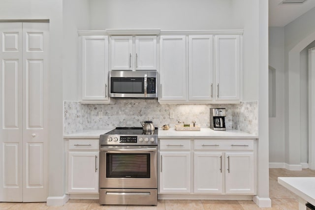 kitchen featuring tasteful backsplash, white cabinetry, and appliances with stainless steel finishes