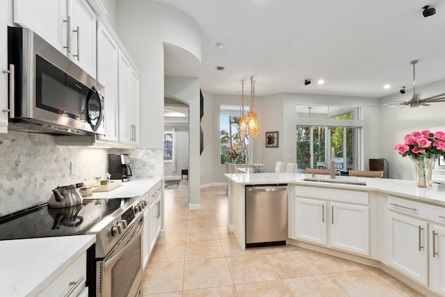 kitchen with tasteful backsplash, decorative light fixtures, white cabinets, and appliances with stainless steel finishes