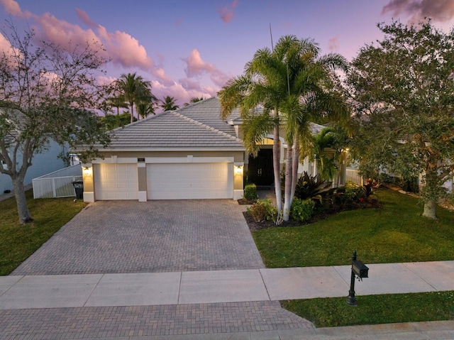 view of front of home featuring a garage and a lawn