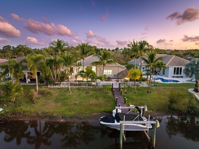 view of dock with a water view and a yard