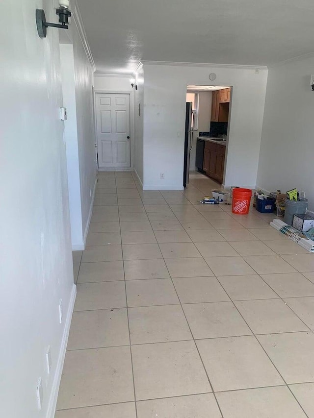 interior space featuring crown molding, sink, and light tile patterned floors