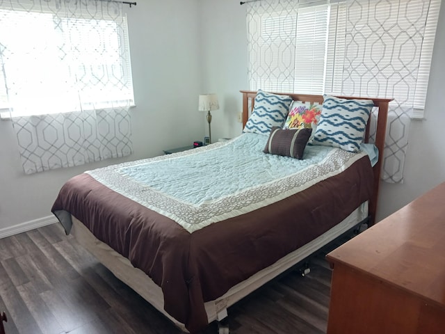 bedroom featuring dark wood-style flooring and baseboards