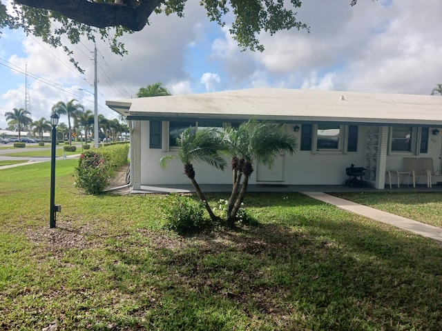 view of front of home with stucco siding and a front yard