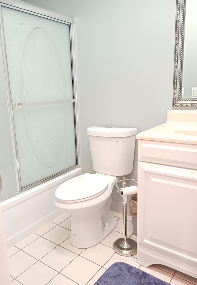 full bath featuring combined bath / shower with glass door, vanity, toilet, and tile patterned floors