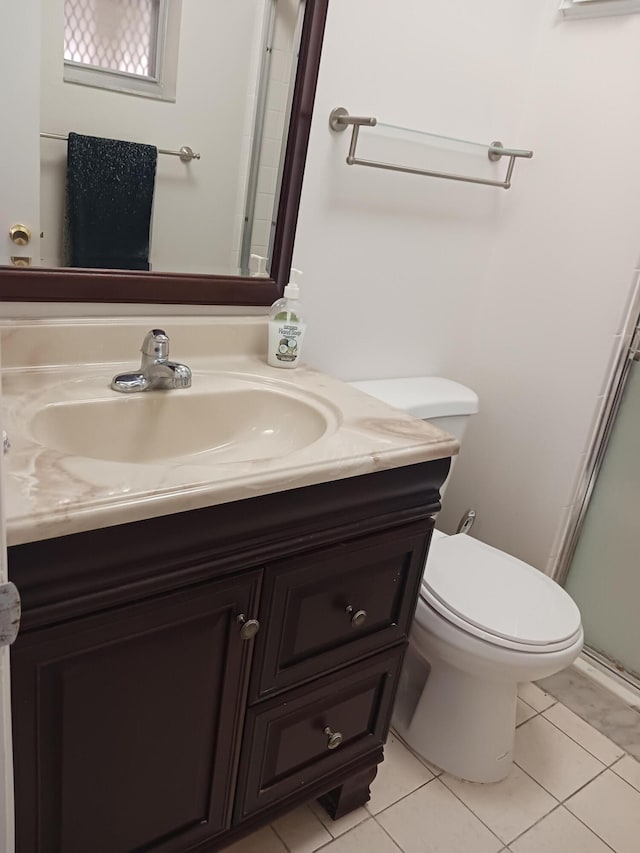 bathroom featuring tile patterned floors, vanity, toilet, and an enclosed shower