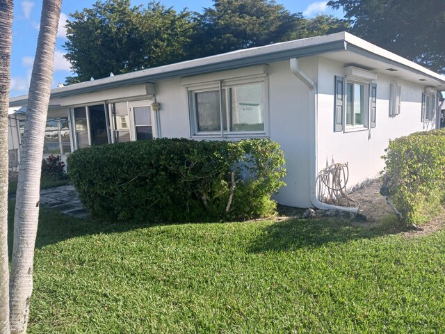 view of side of property with a lawn