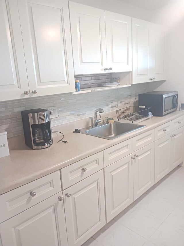 kitchen with tasteful backsplash, white electric range, and white cabinets