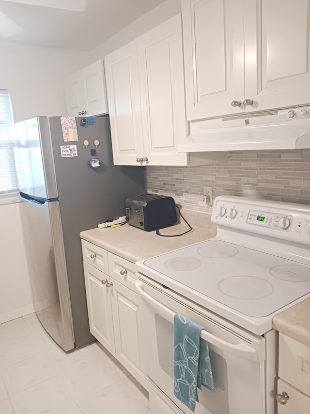 kitchen featuring electric stove, white cabinetry, tasteful backsplash, and stainless steel refrigerator