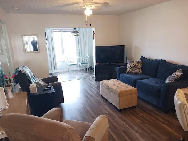 living room featuring a textured ceiling, dark wood finished floors, and a ceiling fan