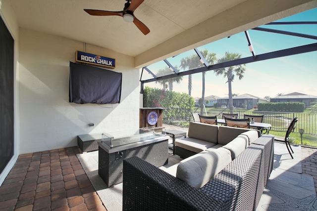 view of patio / terrace featuring an outdoor living space, a ceiling fan, and glass enclosure