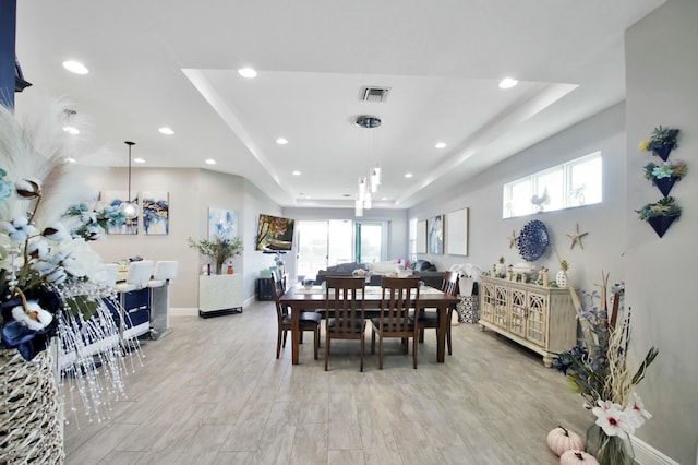 dining area with a tray ceiling, baseboards, visible vents, and recessed lighting