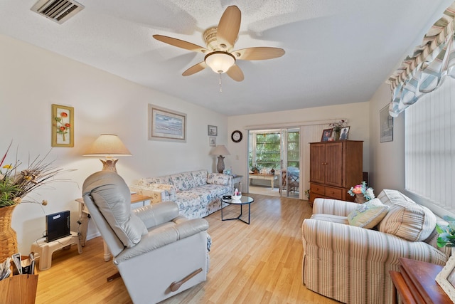 living room with ceiling fan and light hardwood / wood-style floors