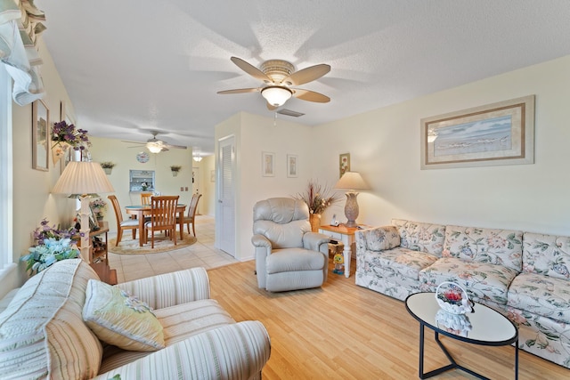 living room featuring ceiling fan, hardwood / wood-style floors, and a textured ceiling