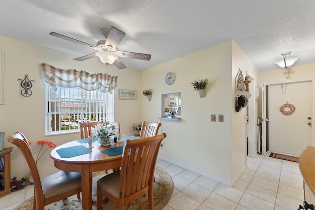 dining area with ceiling fan, a textured ceiling, and light tile patterned floors