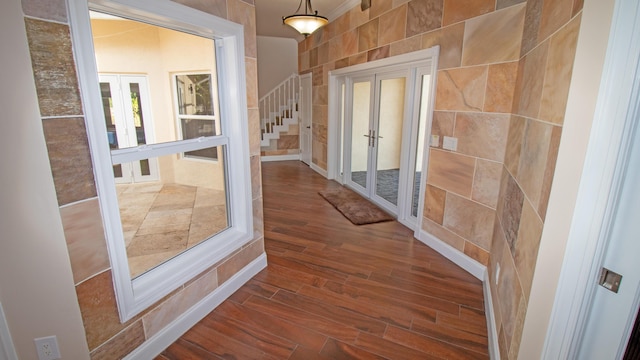 entryway featuring tile walls, dark wood-type flooring, and french doors