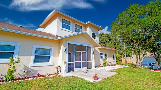 rear view of house featuring a patio and a lawn