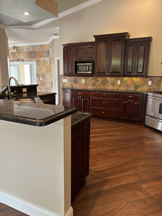 14717 11th Ter, Loxahatchee Groves, FL 33470 - kitchen with appliances with stainless steel finishes, a sink, ornamental molding, dark wood-style flooring, and dark stone countertops