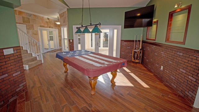 game room with brick wall, billiards, lofted ceiling, hardwood / wood-style flooring, and french doors