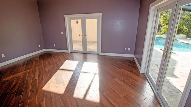 unfurnished room with hardwood / wood-style floors and french doors