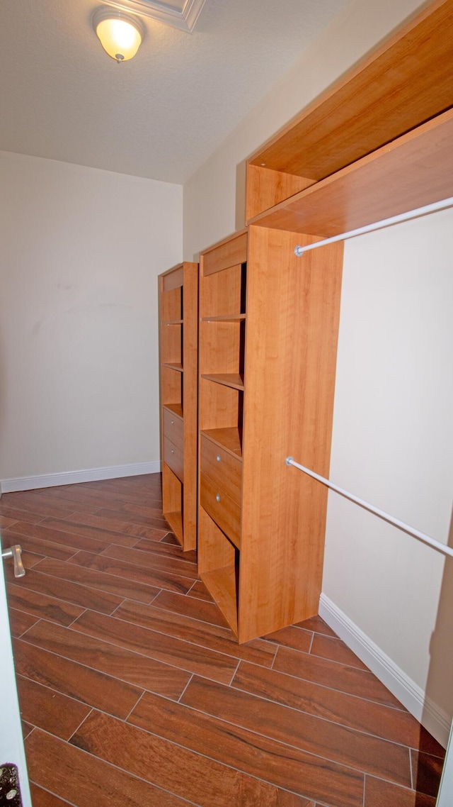 walk in closet with dark hardwood / wood-style flooring