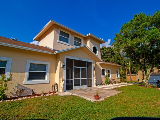 14717 11th Ter, Loxahatchee Groves, FL 33470 - back of house with stucco siding, a lawn, and a patio area