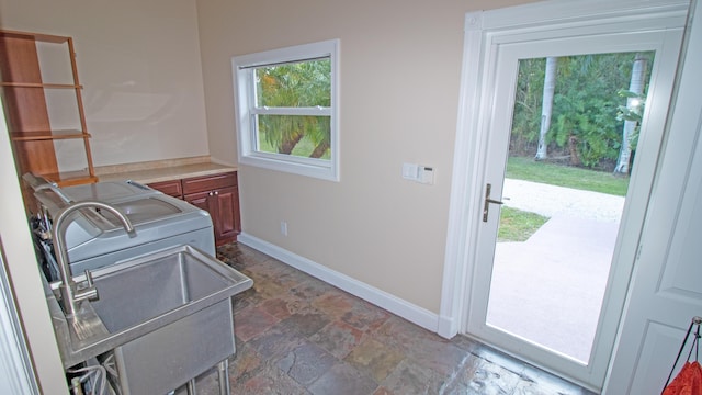 14717 11th Ter, Loxahatchee Groves, FL 33470 - laundry area featuring baseboards, a sink, and dark stone finish flooring