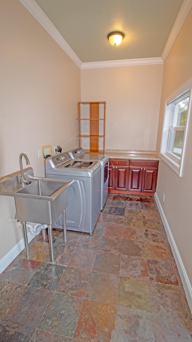 laundry area featuring sink, ornamental molding, cabinets, and washing machine and clothes dryer