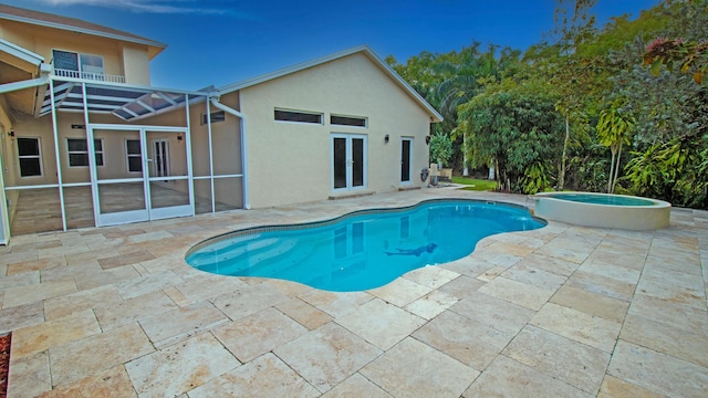 view of swimming pool featuring a patio area, french doors, glass enclosure, and an in ground hot tub