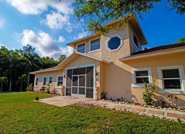 14717 11th Ter, Loxahatchee Groves, FL 33470 - rear view of property featuring stucco siding, a yard, and a patio area
