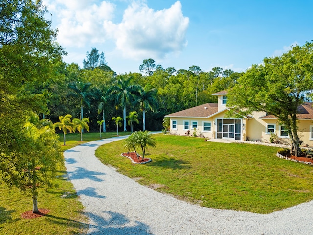 14717 11th Ter, Loxahatchee Groves, FL 33470 - view of front of home featuring gravel driveway, a front lawn, and stucco siding