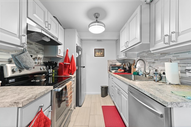 kitchen featuring white cabinetry, appliances with stainless steel finishes, sink, and backsplash