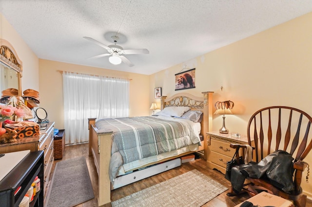 bedroom featuring ceiling fan, wood-type flooring, and a textured ceiling