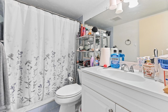 bathroom featuring vanity, tile patterned flooring, toilet, and walk in shower