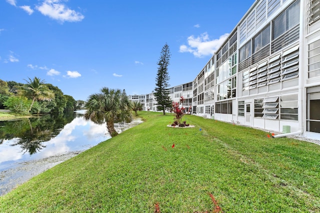 view of home's community featuring a water view and a lawn