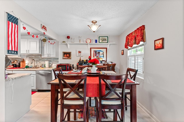 dining room featuring sink and a textured ceiling