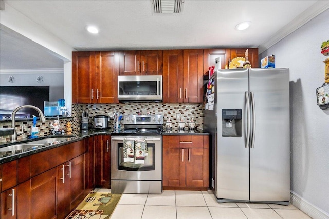 kitchen featuring tasteful backsplash, sink, dark stone countertops, and appliances with stainless steel finishes