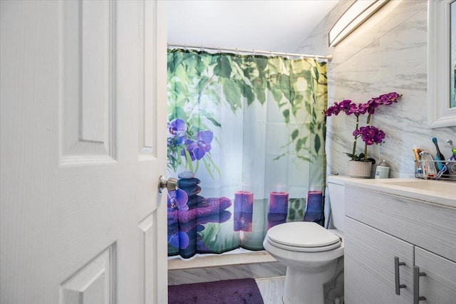 bathroom featuring walk in shower, vanity, and toilet