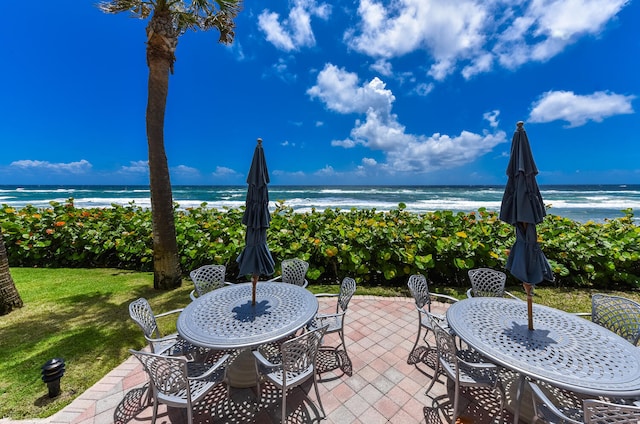 view of patio / terrace with a water view and a view of the beach