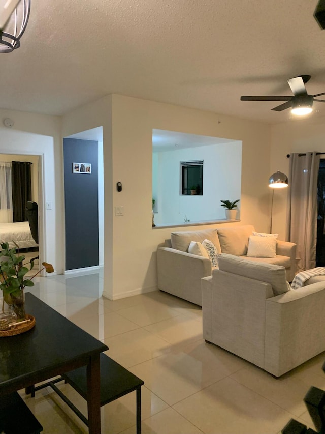 living room with light tile patterned floors, a textured ceiling, and ceiling fan